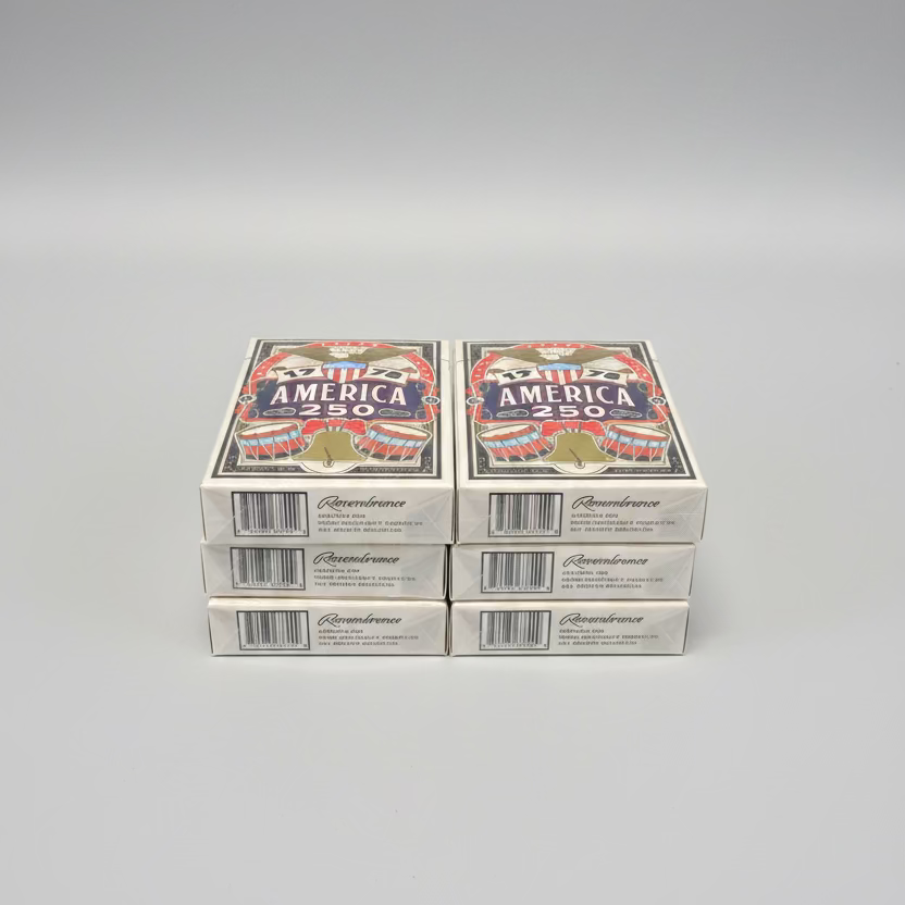 Six decks of the Remembrance America 250 playing cards stacked in two columns on a gray surface
